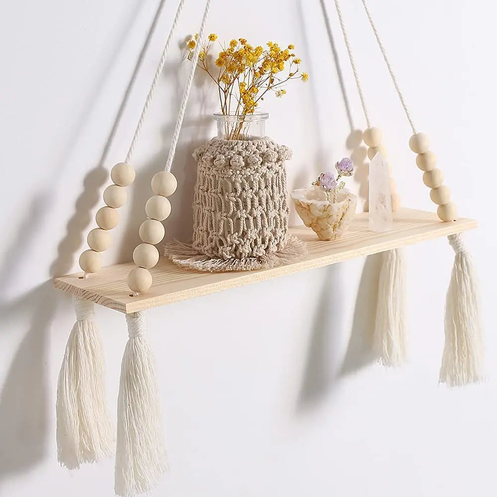 Handmade macrame wood wall shelf featuring a natural fiber plant arrangement and decorative tassels.