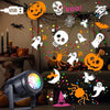 An outdoor LED projector light displaying various Halloween patterns like skulls, bats, and spiders on a dark background.