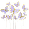 A collection of purple and gold paper butterfly cake toppers on thin sticks.