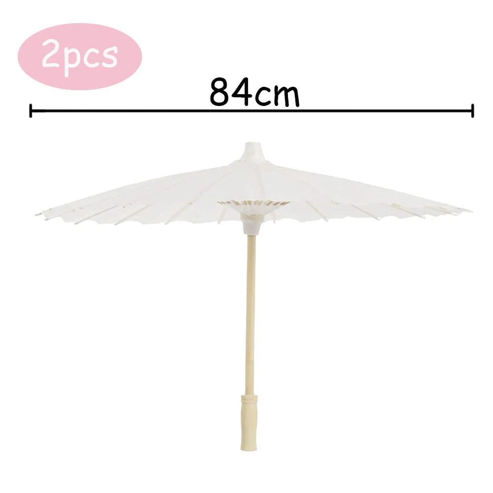 A white decorative paper parasol umbrella with a 84cm span and a light wooden pole.
