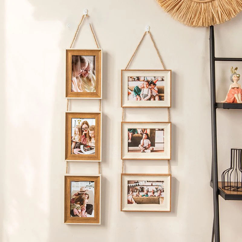 A vertical arrangement of five wooden photo frames hanging on a wall, featuring various portrait and landscape pictures.