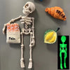 A set of magnetic poseable skull fridge magnets showing a skeleton, a face, and a bread loaf.