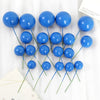 A set of twenty bright blue spherical ball cake toppers with thin green stems arranged on a white background.