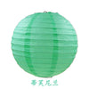 A round, light green paper lantern used for parties and weddings.