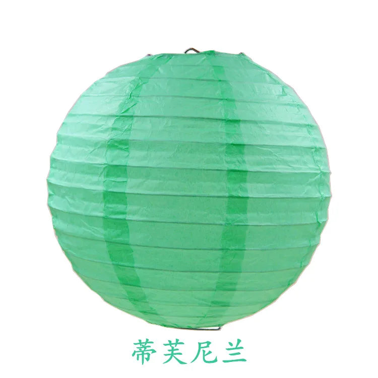 A round, light green paper lantern used for parties and weddings.