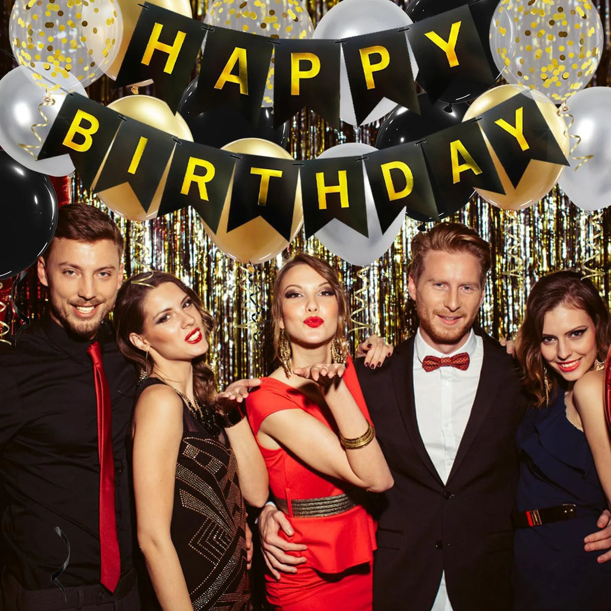 A group of five people posing in front of a banner that reads Happy Birthday made of black and gold decorations.