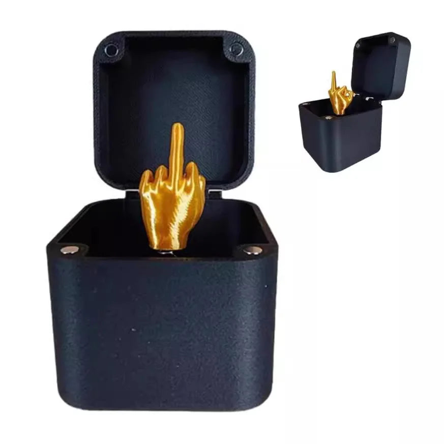 Une boîte cadeau noire à couvercle ouvert révélant un geste de main doré à l'intérieur.