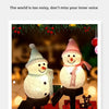 A festive snowman made of lights standing outdoors in a snowy setting.