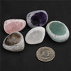 A collection of tumbled natural crystals including pink rose quartz, purple amethyst, and green jade-like stones.