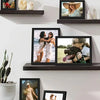A set of five black wooden picture frames displaying various photographs and artwork for wall display.