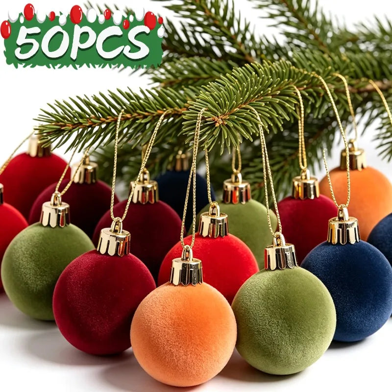 A set of five velvet flocked Christmas tree ornaments in various shades of red, green, and blue hanging from pine branches.