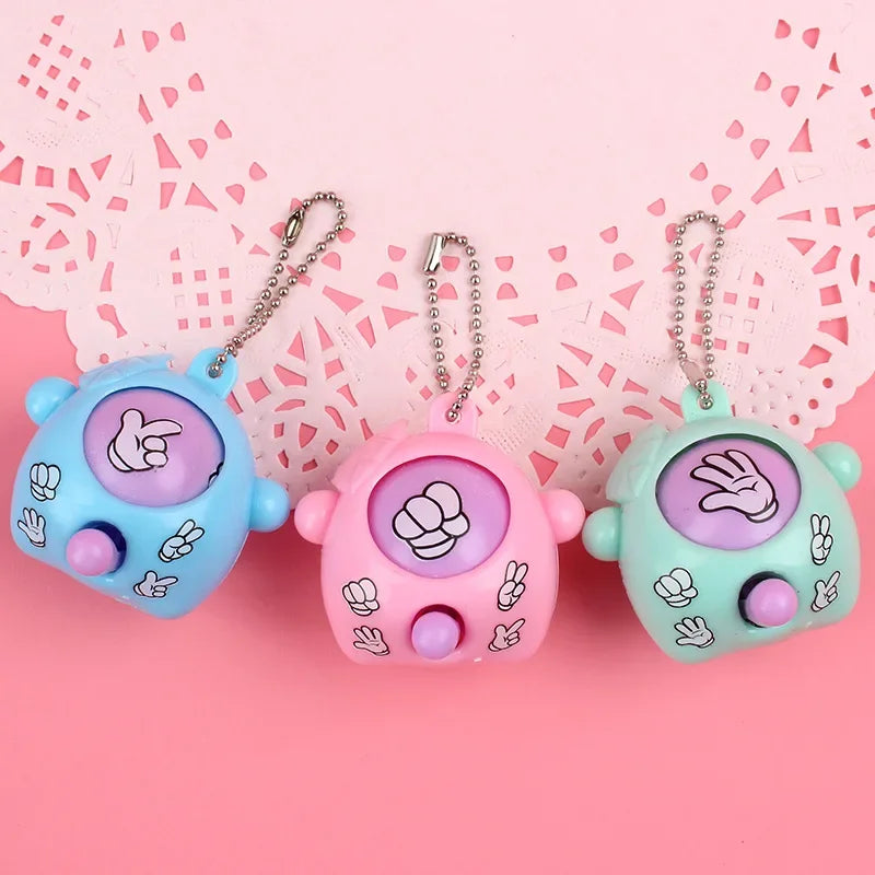 Three colorful guessing game eggs with handprints are displayed against a pink lace background.