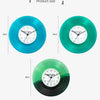 Three versions of a vintage vinyl record wall clock with transparent covers in blue, green, and dark green.