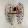 Boho wood angel wing wall shelf displaying crystals and a candle.