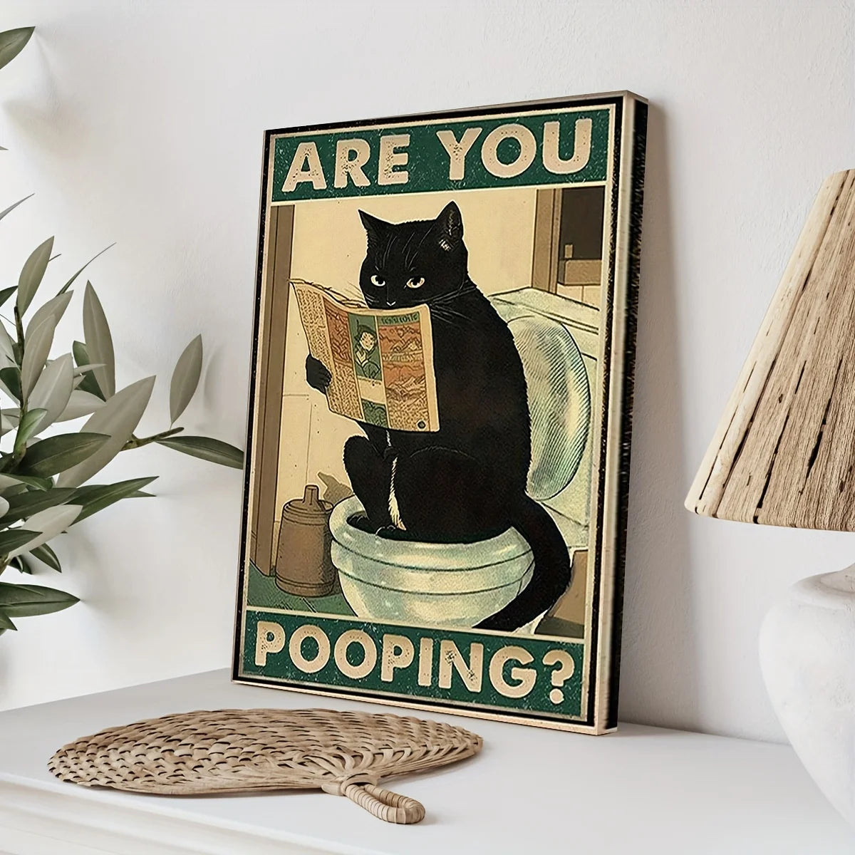 A framed poster featuring a black cat looking surprised and asking Are you pooping?