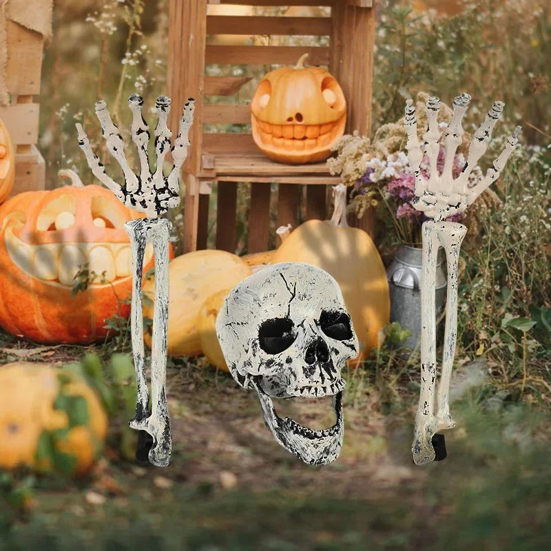 Realistic skeleton hand lawn stakes used for Halloween graveyard decor surrounded by pumpkins and foliage