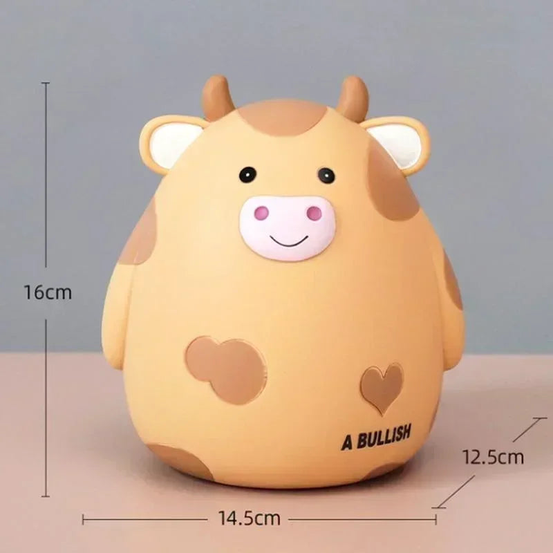 A cute, light yellow cartoon cow figurine shaped like a piggy bank or coin holder.