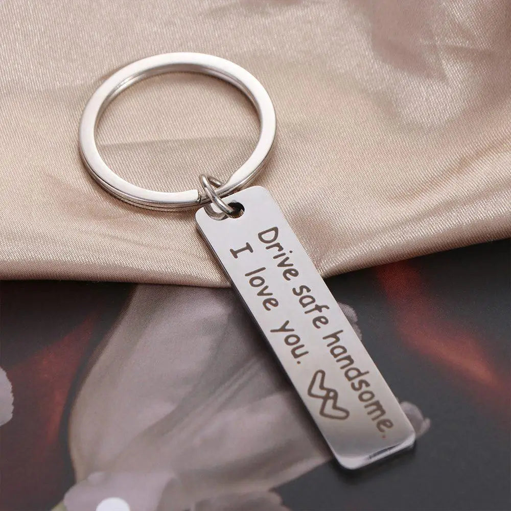 Silver stainless steel keychain with an engraved tag that reads I drive safe handsome I love you