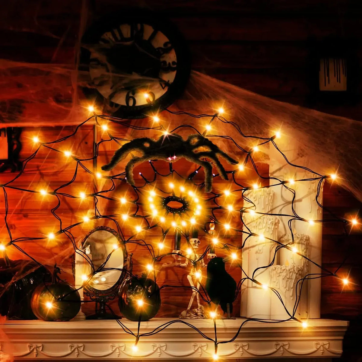 Halloween spider web LED string lights illuminating a decorative display on a mantelpiece.