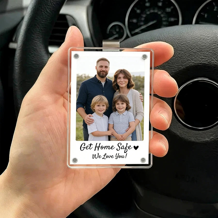 A hand holds a clear photo clip featuring two smiling people with text that reads Get Home Safe We Love You