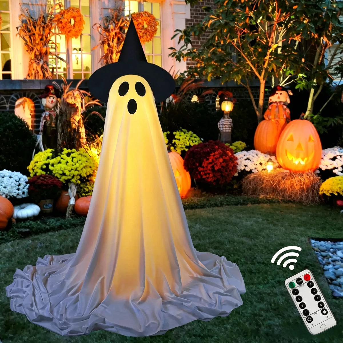 A large, glowing white ghost decoration with black features stands in a garden setting.