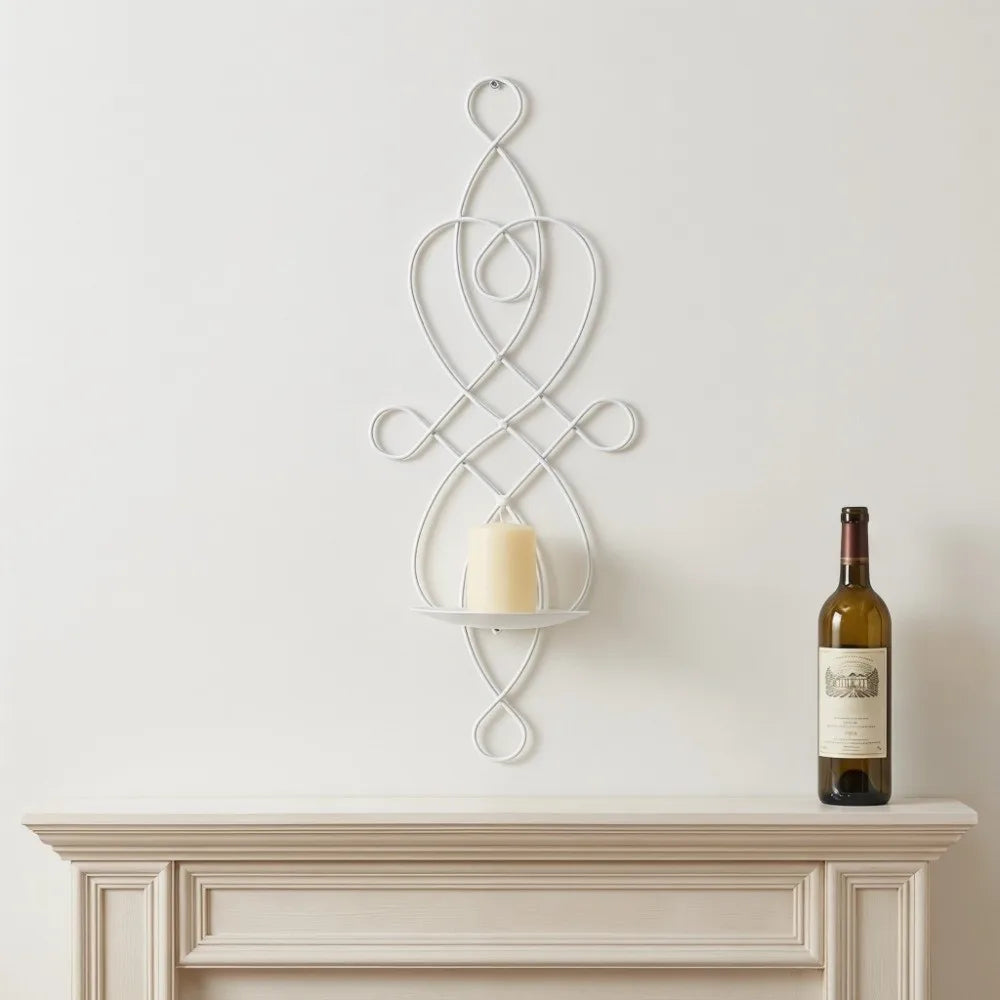 A white decorative iron wall candle sconce set with an intertwined, swirling design mounted on a light gray wall above a mant