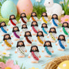 A collection of mini rubber Jesus figurines in white and pink, set against a spring-themed background with eggs and flowers.