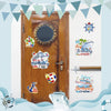 A set of seven decorative magnets featuring a birthday cruise theme displayed on a wooden door.