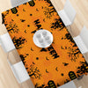 Orange tablecloth featuring a black Halloween pumpkin and ghost pattern.