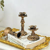 A vintage resin wall sconce candle holder displayed on a gold tray next to a book.