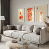 A modern living room features a light sofa, decorative pillows, and framed art prints on the wall.