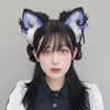 A close-up photo of a woman wearing a black and white shirt with large, fluffy fox ears headband featuring purple accents.