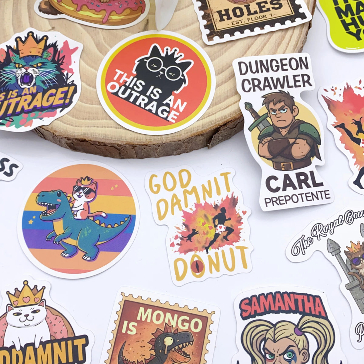 A collection of colorful graffiti stickers featuring characters and text like This Is An Outrage, Dungeon Crawler, and God Da