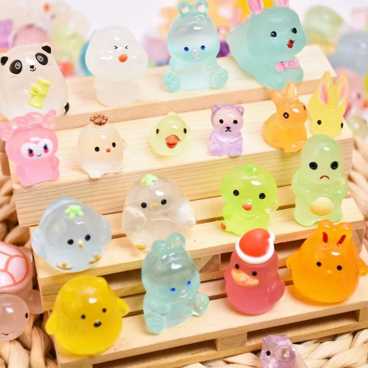 A collection of glowing resin animal figurines in various colors and shapes arranged on a wooden tray.