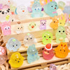 A collection of glowing resin animal figurines in various colors and shapes arranged on a wooden tray.