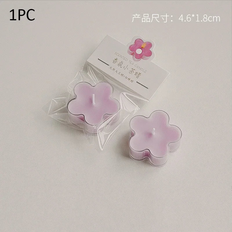 A single pink scented tea light candle in a clear plastic wrapper is shown on a white background.