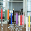 A collection of twenty hand-poured soy wax stick candles in various colors including red, green, orange, blue, and purple