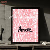 A framed print featuring abstract pink script text that reads Amore on a white background.