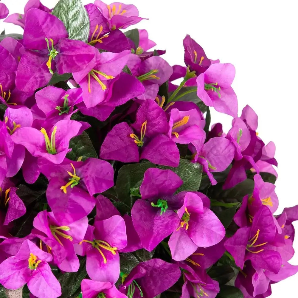 A cluster of vibrant purple faux bougainvillea vine flowers on green leaves.