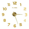 A golden acrylic wall clock face showing the time, with large numbers and hands.