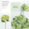 A bouquet of light green artificial hydrangea flowers displayed in a glass container.