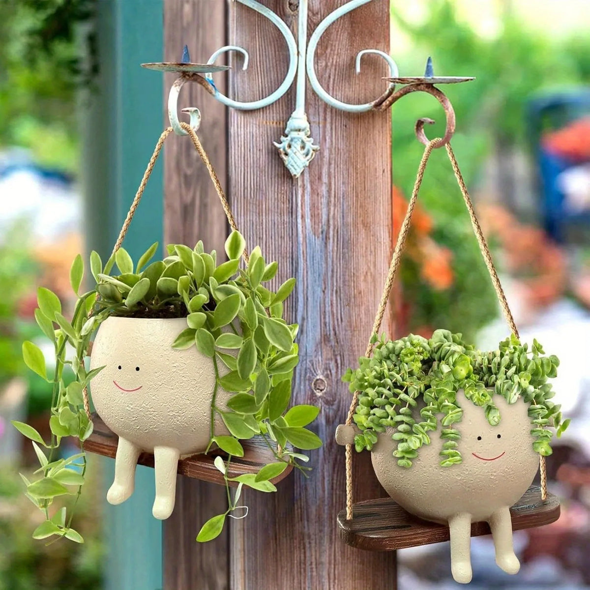 A hanging resin succulent planter with a green plant is displayed on a wooden fence post.