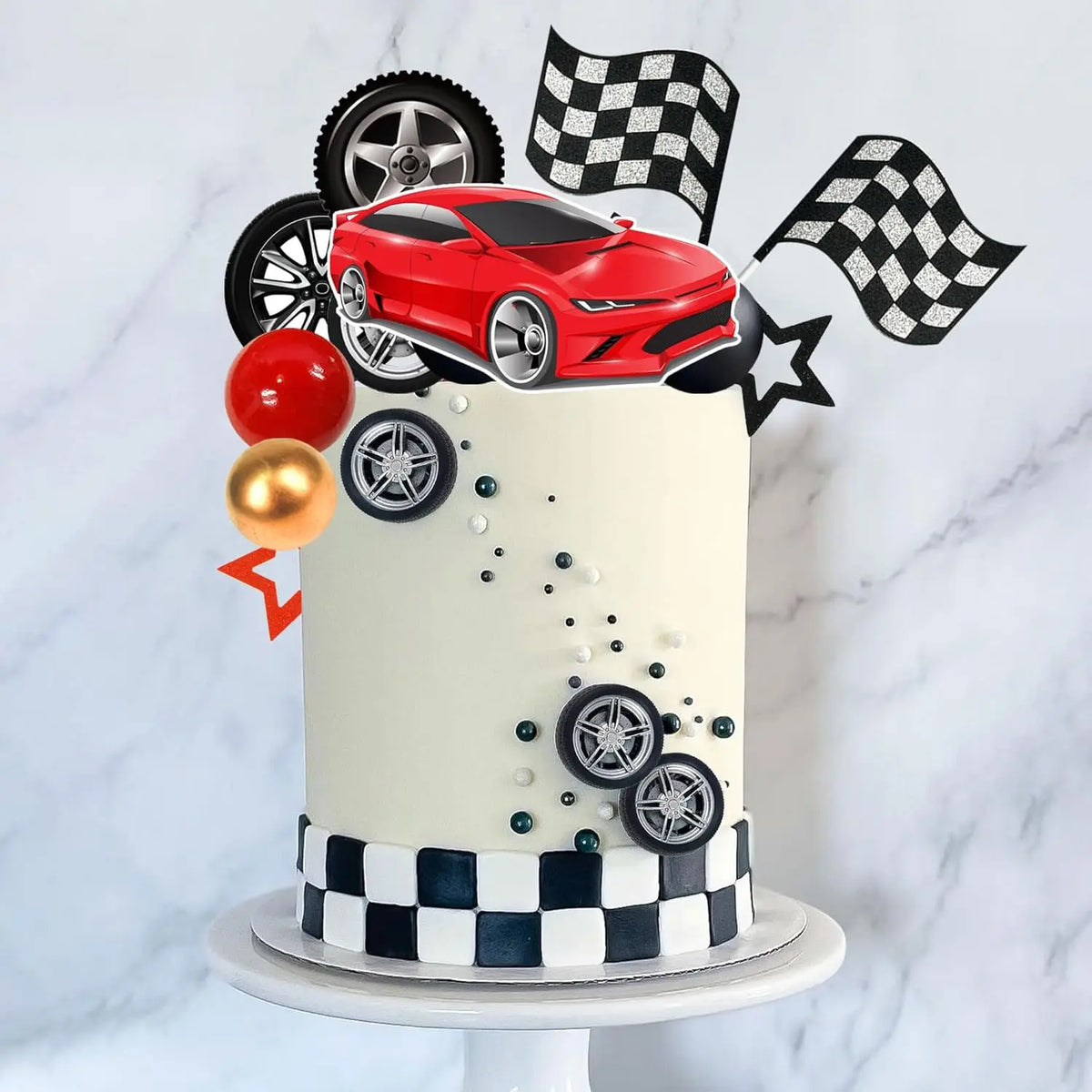 A tiered cake decorated with a red racing car topper, black and white checkered accents, and gold spheres.