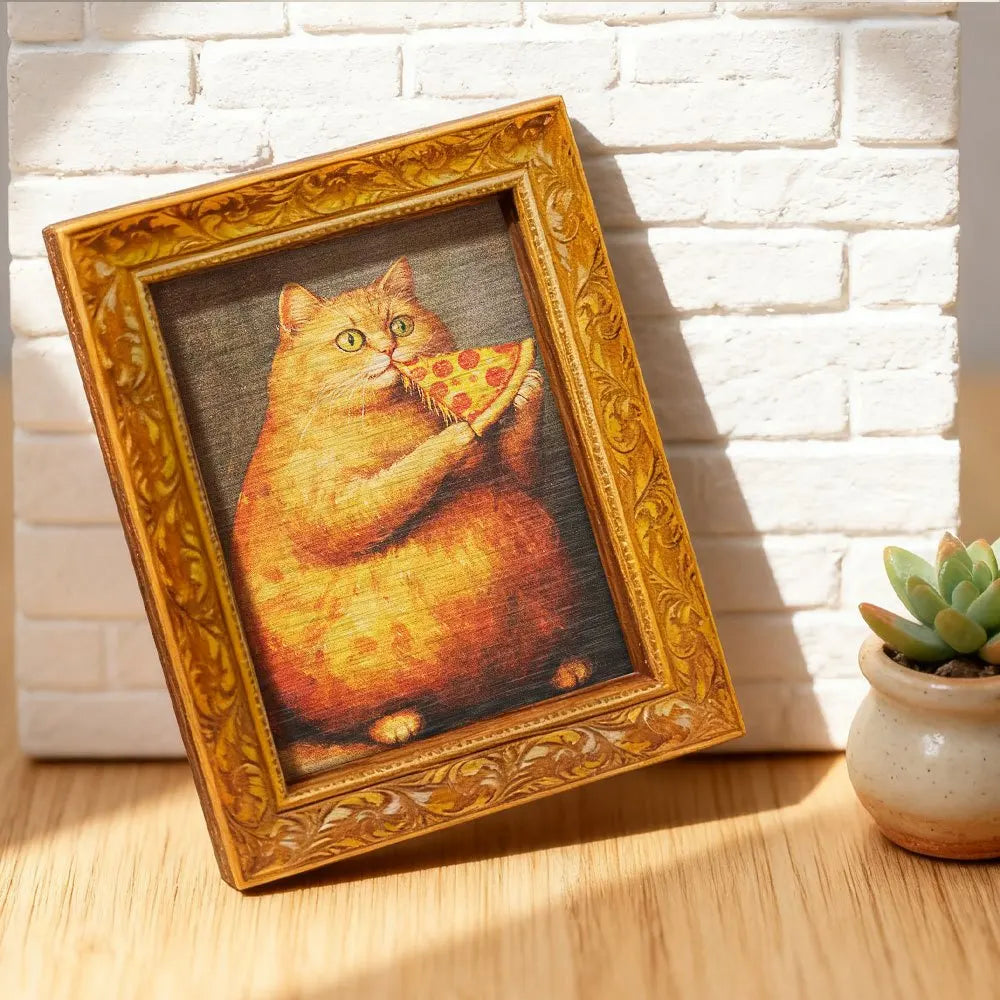A framed painting of an orange cat eating a slice of pizza