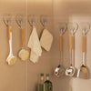 A set of ten transparent self-adhesive hooks for hanging kitchen utensils on a beige tiled wall.