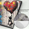 A vibrant heart-shaped balloon featuring paint drips and a silhouette of a child, displayed on canvas.