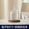 Clear glass aromatherapy candle holder with a decorative top and a wooden base