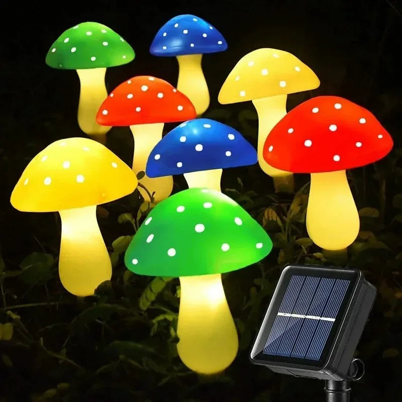 A set of six illuminated mushroom garden lights in various colors, including green, yellow, red, and blue, mounted on a solar