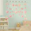 Pink tassel door curtain featuring heart and star decorations hanging against a light blue wall.