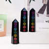 A set of black obsidian crystal towers with various colored gemstone tops displayed on a white surface.